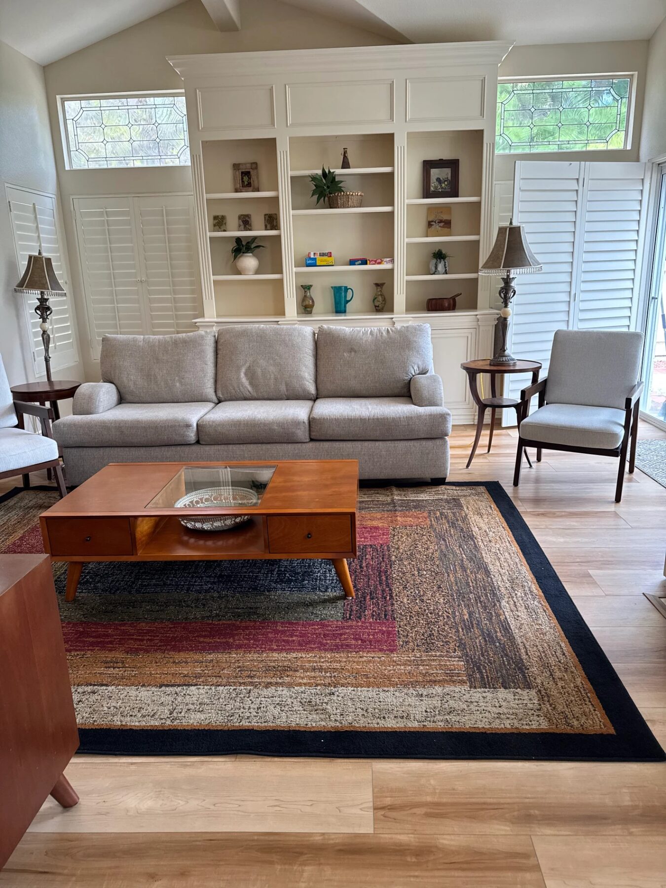 Living room with white built-in shelving, vacuumed area rug and polished wood floors after a Scrub Bros clean